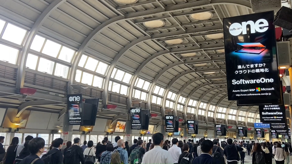 A group of people walking through a train station.