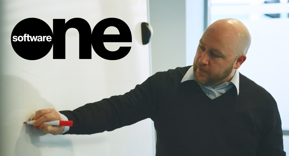 A man writing on a whiteboard with the words software one.