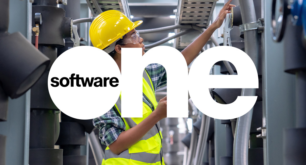 A man in a hard hat is working in a factory with the software one logo.