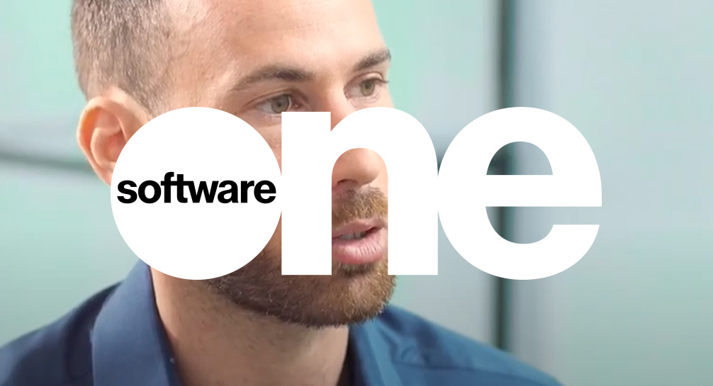 A man in a blue shirt with the words software one in front of him.