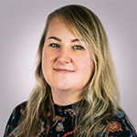 A woman in a floral top is posing for a photo.