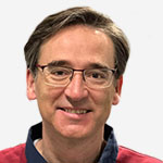 A man wearing glasses and a maroon shirt.