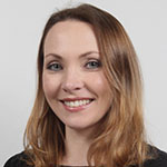 A woman in a black shirt smiling for the camera.