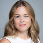 A woman with long hair and blue eyes is posing for a photo.