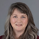 A portrait of a woman wearing a maroon shirt.