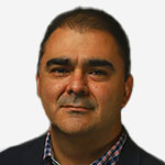 A man wearing a suit and a blue shirt.