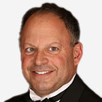 A man in a tuxedo smiling for the camera.