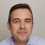 A man in a blue shirt is posing for a photo.