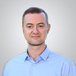 A man in a blue shirt is posing for a photo.