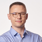 A man wearing glasses and a blue shirt.