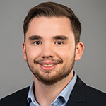 A man with a beard is smiling for the camera.