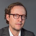 A man in glasses is posing for a photo.