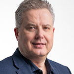 A man in a blue shirt is posing for a photo.