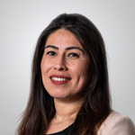 A woman with long hair and a blazer posing for a photo.