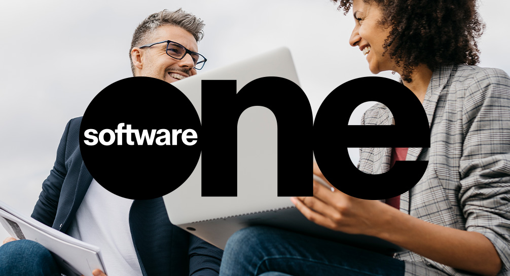 Software one logo with two people sitting in front of it.