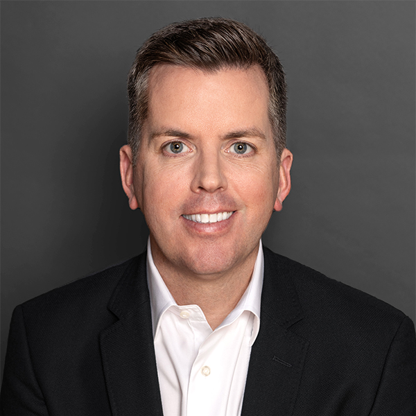 A man in a suit is smiling for the camera.